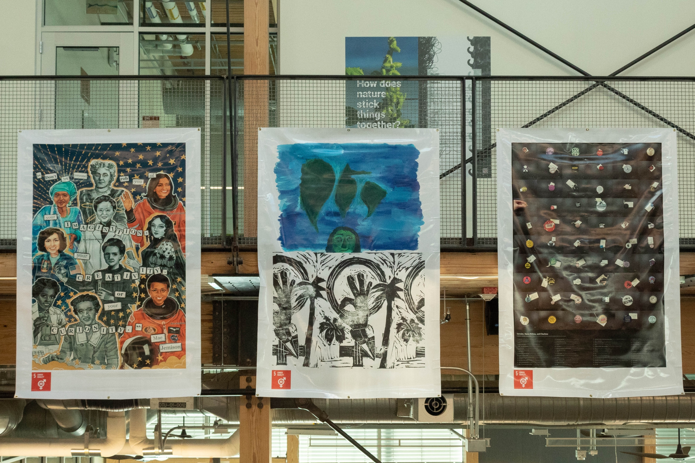 Banners from left to right: “The Named Pioneers” by Kelly Lin, “Pensamientos Isleños, and Tropical Feminism” by Alexandra Rodriguez Dalmau, and “Lorraine, Maria Helena, and Charlene” by Alexandra Teixeira Riggs hanging from the second-floor of The Kendeda Building.